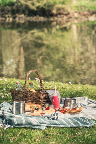 Картината върху платно Picnic in the grass: picnic basket, bottle of fruit juice, fruits, fruit salad,