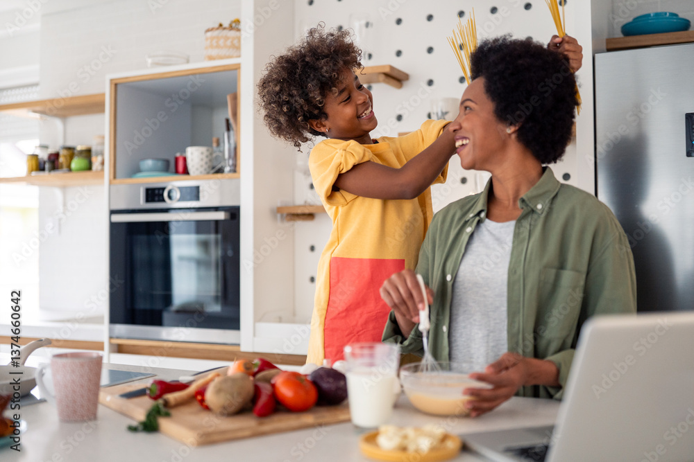 Playful African Mother and Daughter Cooking Together in a Bright Modern Kitchen Playful African Mother and Daughter Cooking Together in a Bright Modern Kitchen
