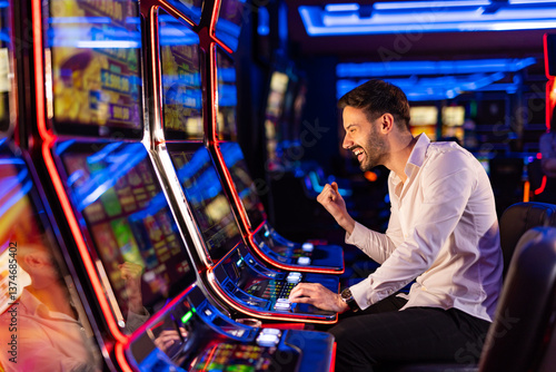 Cuadro en lienzo Excited Man Winning on Slot Machine in Vibrant Casino Setting