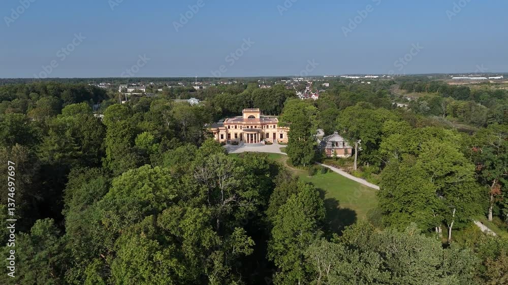 Aerial drone video of Trakų Vokė Manor near Vilnius, Lithuania, highlighting its neoclassical facade, featuring symmetrical formal gardens, a central fountain, and lush surrounding parkland. Aerial drone video of Trakų Vokė Manor near Vilnius, Lithuania, highlighting its neoclassical facade, featuring symmetrical formal gardens, a central fountain, and lush surrounding parkland.
