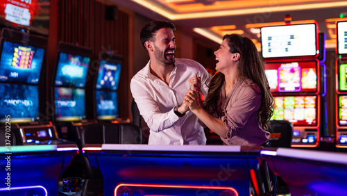 Happy Couple Celebrating Together in a Casino Playing Slot Machines