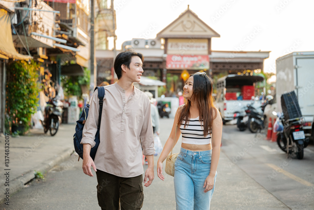 Fototapeta premium Young tourists couple walking in bangkok street market exploring thailand
