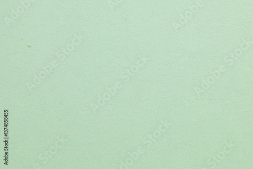 A green background with a white object in the middle, textured origami paper backdrop
