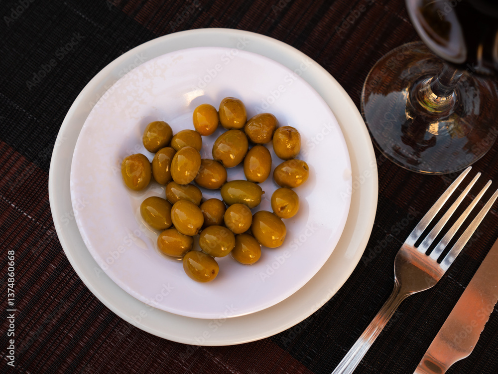 Bunch of large green olives with pits served in bowl Bunch of large green olives with pits served in bowl