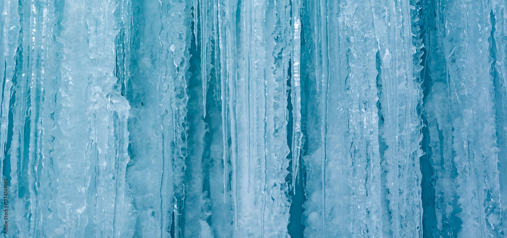 Fototapeta premium Cold winter icicles melting banner. Blue frozen ice close-up photograph.