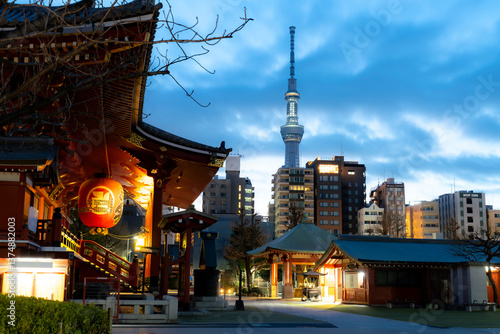 Photography Early morning view from Senso-ji Temple in Asakusa, Tokyo, Japan, with the illuminated Tokyo Skytree rising behind city buildings