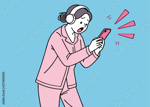 Asian woman in pink pajamas wearing headphones looks shocked while staring at her pink smartphone, standing against a solid blue background, reacting strongly to something unexpected