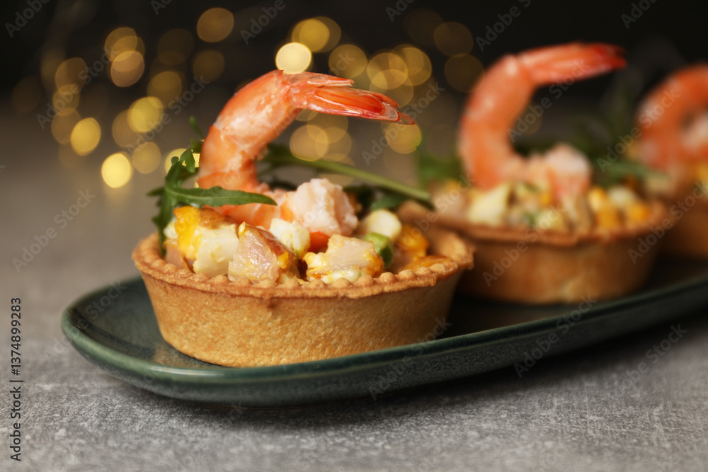Tartlets with delicious filling on grey table, closeup. Bokeh effect Tartlets with delicious filling on grey table, closeup. Bokeh effect