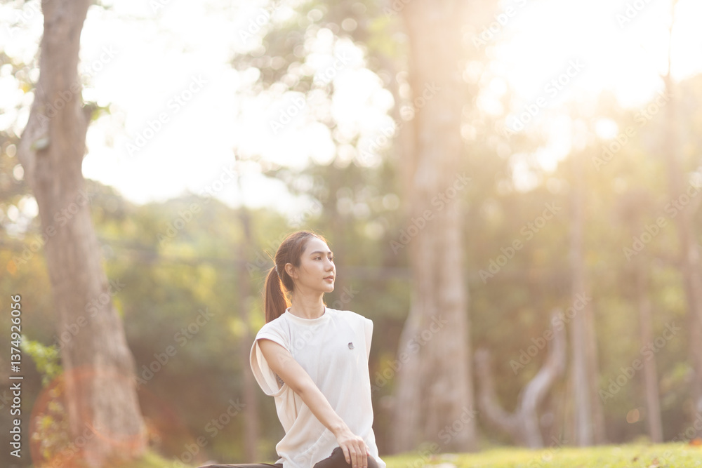 Naklejka premium A enthusiastic Asian sports woman stopped after exercising at the garden, sitting on a exercise mat, inhaling deeply by closing her eyes. Sports and exercise regularly Health and health