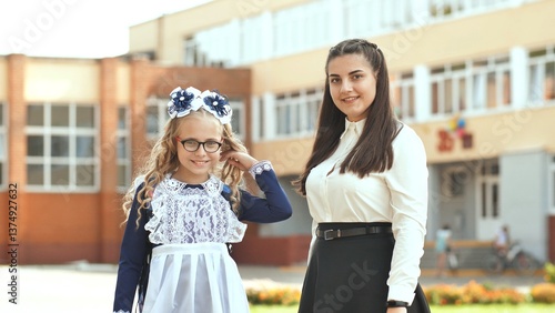 Quadro su tela Two Russian schoolgirls sisters posing in festive clothes on the day of the beginning of the school year