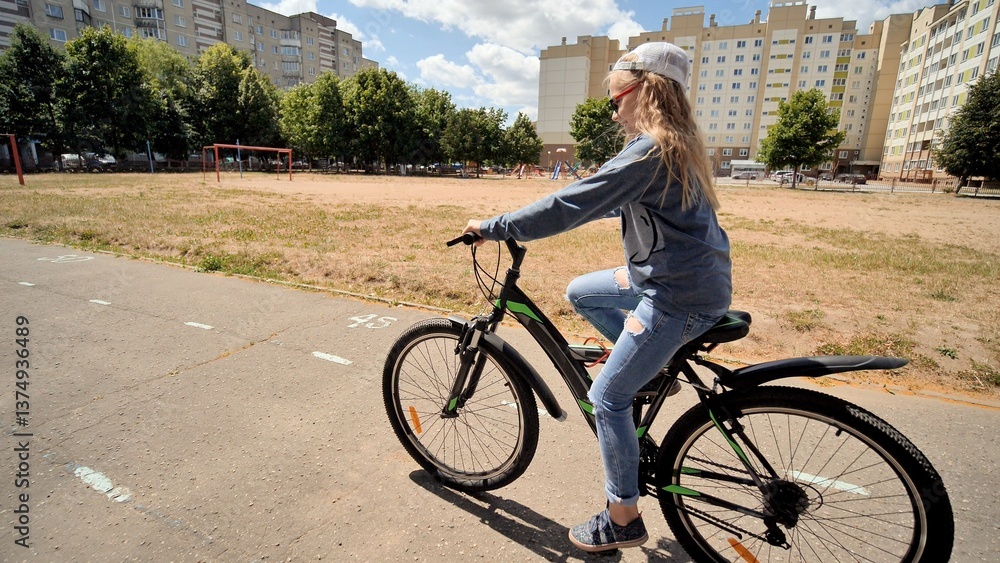 Obraz premium Young student enjoying cycling in a city park, promoting healthy lifestyle and outdoor activities for children