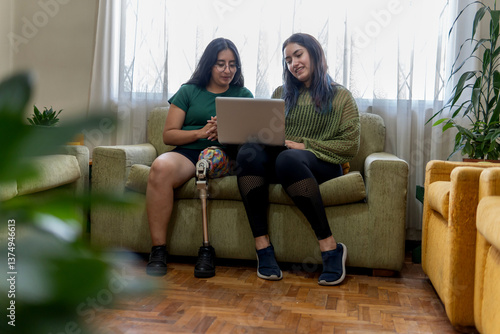Two latin women working from home using laptop and showing inclusion and diversity
