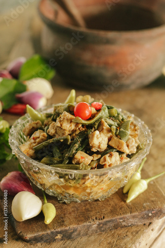 Stir-fried long beans mixed with tempeh in bowl. Tumis kacang panjang campur tempe. Indonesian traditional cuisine. Selective focus.