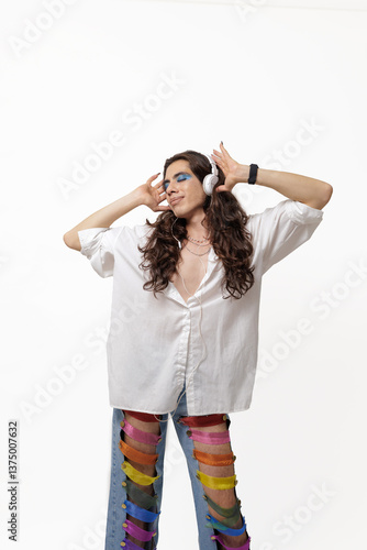Genderless person listening to music and happy with their pride pants on a white background with copy space