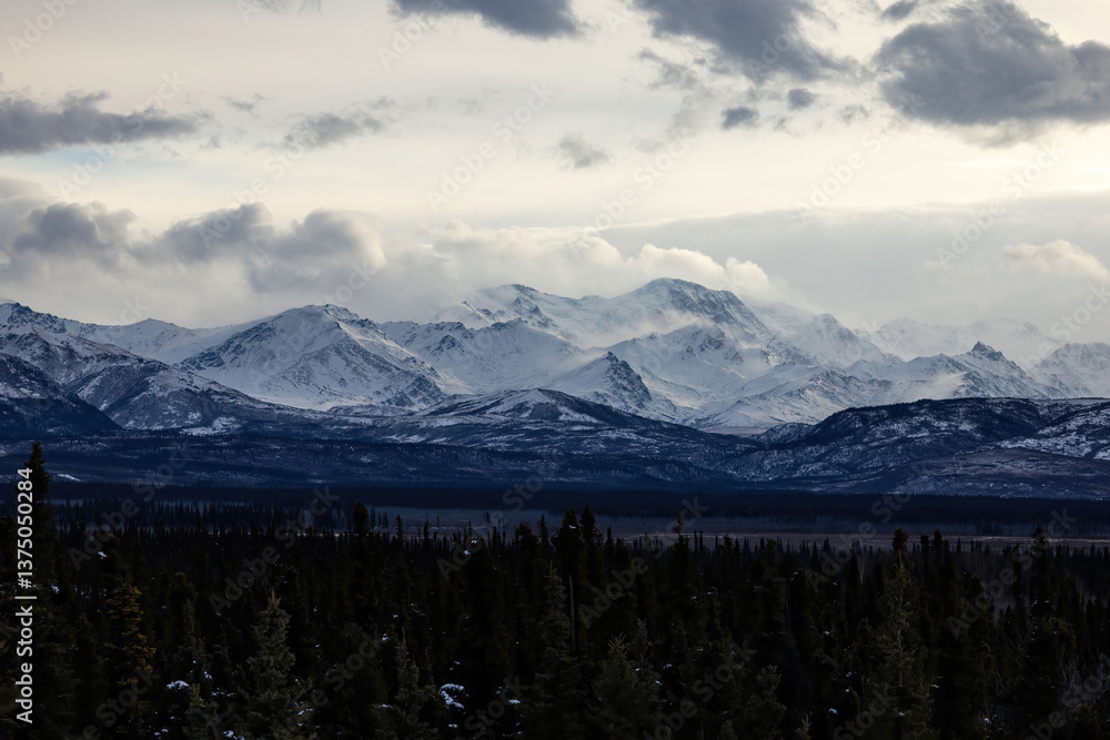 Fototapeta premium Low clouds over snowy mountains in interior Alaska.