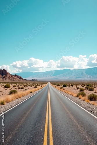 Asphalt ribbon unfurls towards a distant mountain range under a vibrant summer sky, promising adventure and open road freedom.