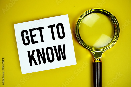 Get to know text on paper card with magnifying glass flat lay on yellow background