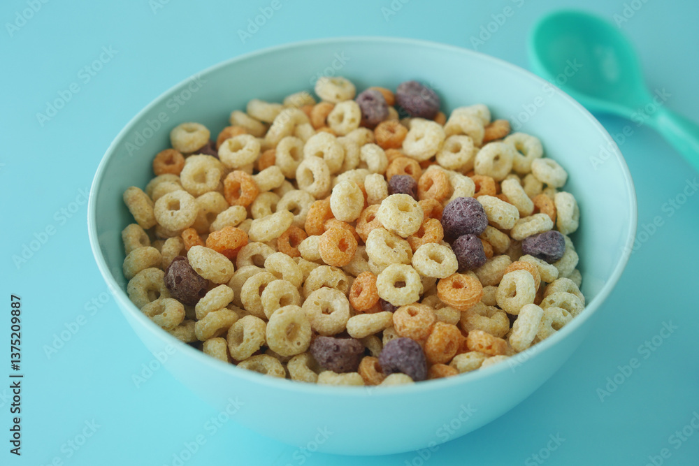 Colorful cereal in a bowl on a light blue surface Colorful cereal in a bowl on a light blue surface