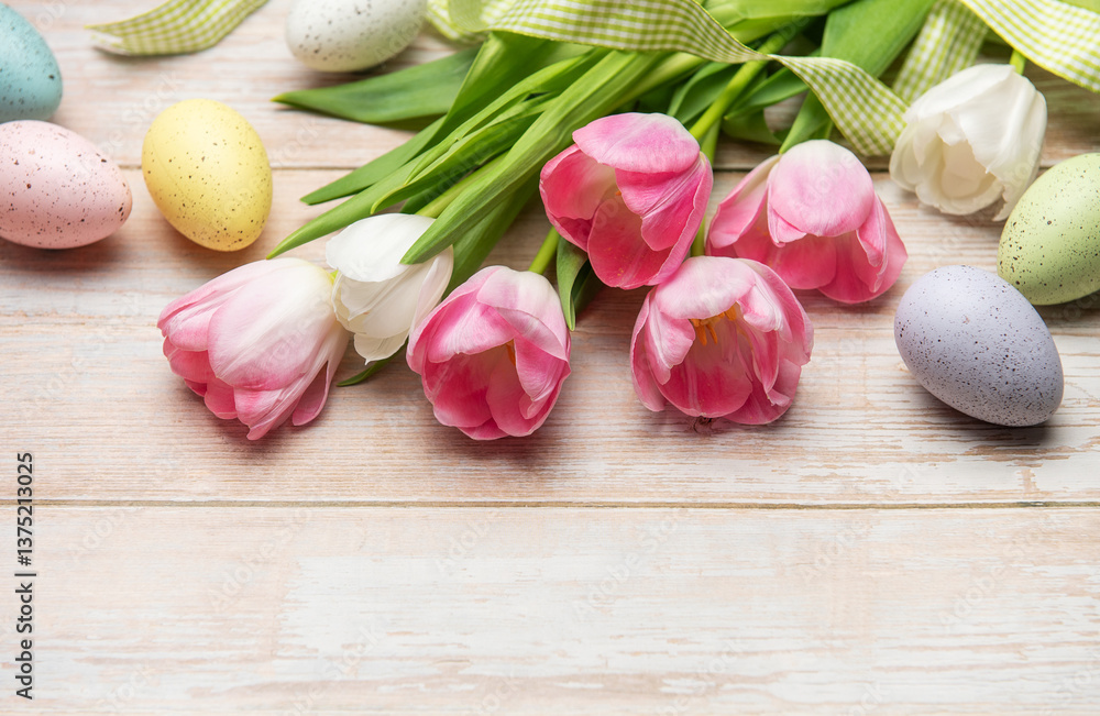 Easter eggs and pink tulips resting on white wooden table Easter eggs and pink tulips resting on white wooden table