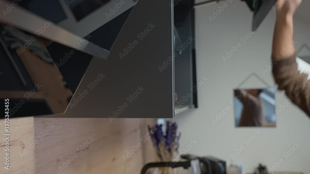 Man opens upper kitchen cabinet and takes drinking glass. Hand opens cupboard with transparent glasses Man opens upper kitchen cabinet and takes drinking glass. Hand opens cupboard with transparent glasses