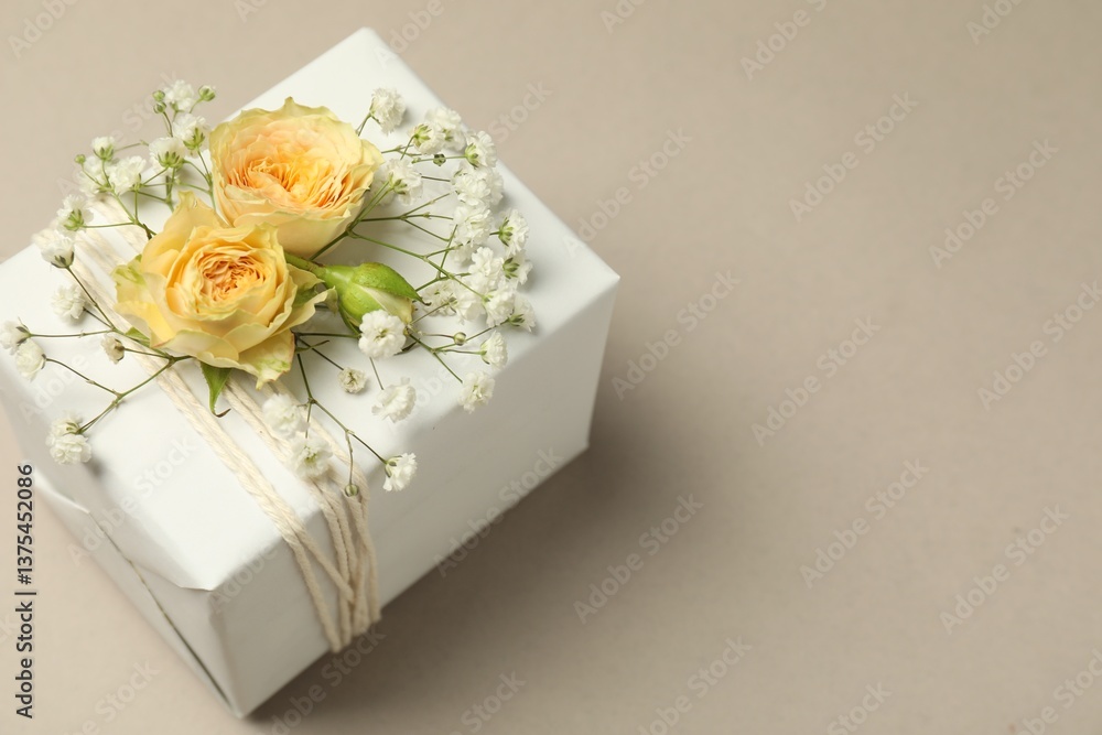 Florist. Box with flowers on light grey background, closeup. Space for text Florist. Box with flowers on light grey background, closeup. Space for text