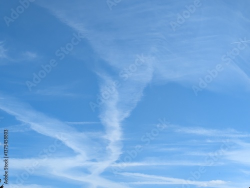 Blue Skies with wispy chemtrail aeroplane lines and fluffy white clouds