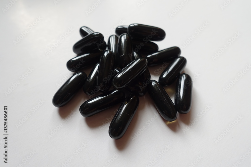 Heap of black softgel capsules of activated charcoal