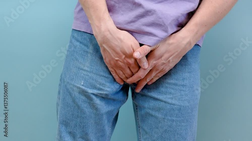 Man hold hand in front of private parts feeling discomfort from disease and inflammation. Venereal, testicular cancer. bladder problems, erectile dysfunction, premature ejaculation, prostate cancer