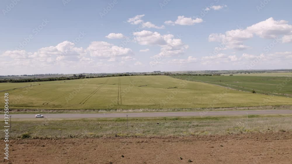 A drone captures an aerial view of a road stretching through the countryside, surrounded by natural landscapes. Perfect for travel, transportation, and rural scenery themes. A drone captures an aerial view of a road stretching through the countryside, surrounded by natural landscapes. Perfect for travel, transportation, and rural scenery themes.