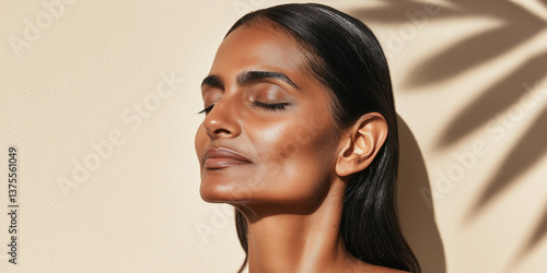 Mature Indian woman with clean natural face and beige background with leaf shadows