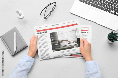 Woman reading newspaper at ...