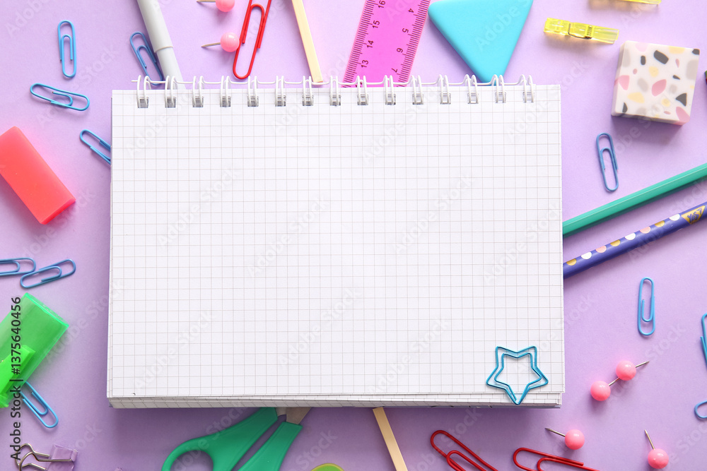 Composition with blank notebook and different school stationery on purple background Composition with blank notebook and different school stationery on purple background