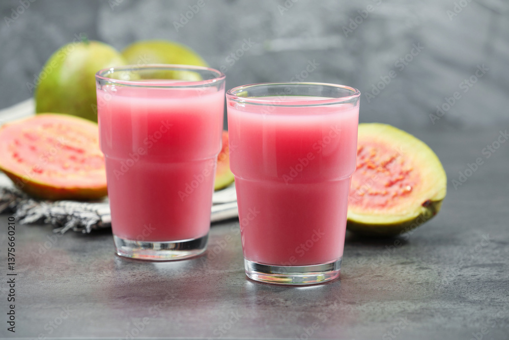 Refreshing guava juice and fresh fruits on grey table, closeup Refreshing guava juice and fresh fruits on grey table, closeup