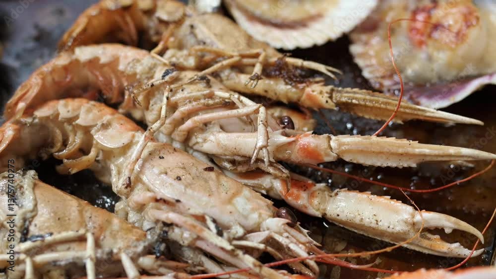 Close up of various grilled seafood, including norway lobster, shrimp, and scallops, sizzling on a hot surface Close up of various grilled seafood, including norway lobster, shrimp, and scallops, sizzling on a hot surface