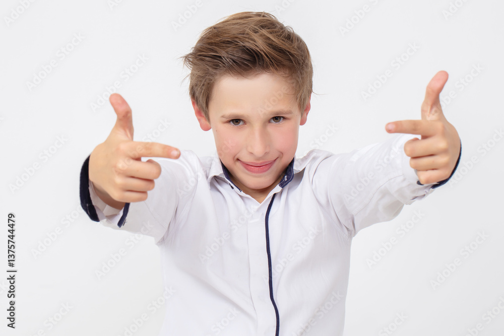 A school-age boy in a white shirt shows a sign of success with his fingers. A school-age boy in a white shirt shows a sign of success with his fingers.