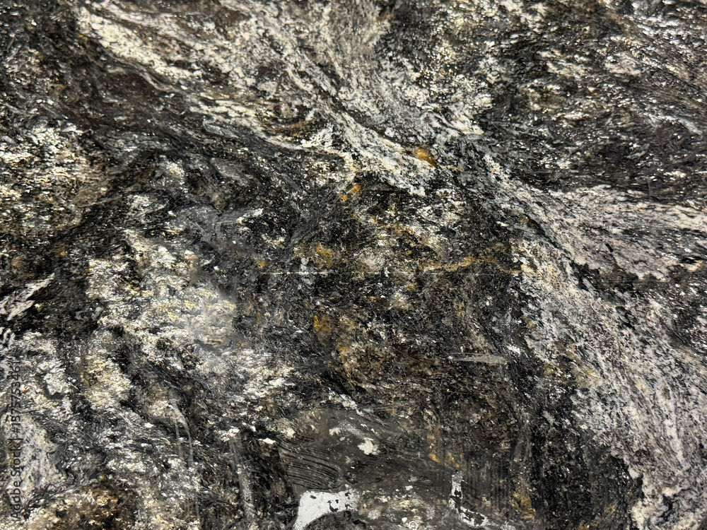Natural black and white granite slab pattern with orange brown color shades. Shimmering black and grey grains granite with random stone pattern. Natural minerals seamless background texture. Natural black and white granite slab pattern with orange brown color shades. Shimmering black and grey grains granite with random stone pattern. Natural minerals seamless background texture.