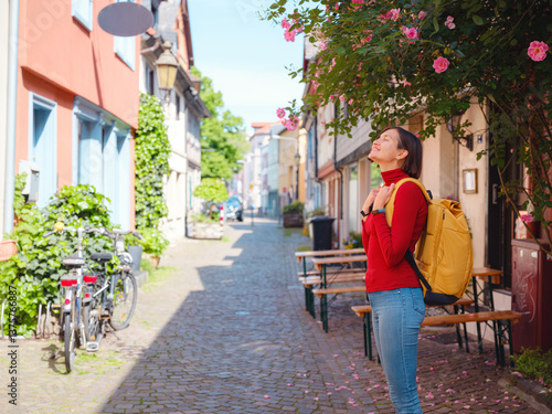 Bilde på lerret Tourist woman enjoys historic charm of Hochst near Frankfurt, wandering through picturesque streets with old houses and cobblestone alleys, soaking in peaceful atmosphere of old town