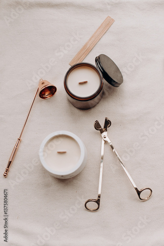 A collection of wooden wick candles along with candle-making and usage accessories, including wick trimmers, a candle snuffer, and matches