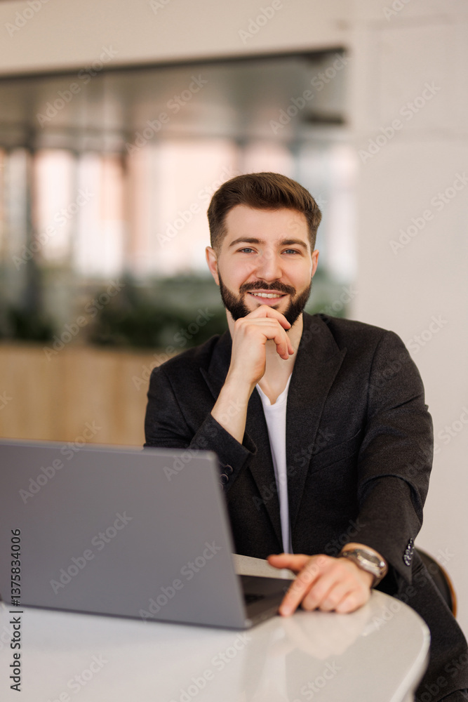 Portrait of a businessman man in a yellow shirt working on a laptop in the office Portrait of a businessman man in a yellow shirt working on a laptop in the office