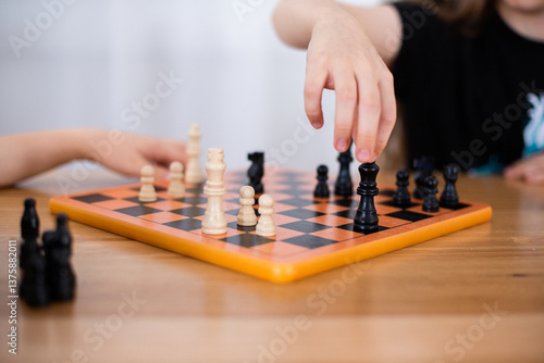 child grabbing a chess piece to move it during a game