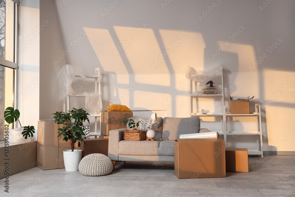 Fototapeta premium Empty living room with moving boxes and furniture, relocation and home transition concept, new apartment interior