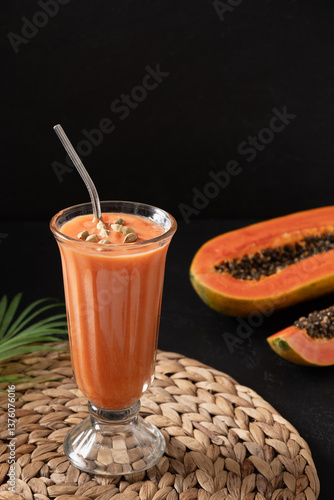 Obraz na płótnie Asian traditional papaya lassi on dark background. Freshness cold beverage of yogurt, water, spices, fruits and ice. Popular beverage in India and Sri lanka. Vertical format. w salonie