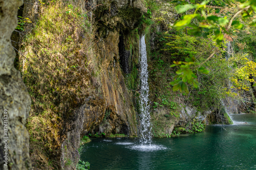 Fototapeta premium Beauty in spring nature, amazing waterfall in forest. Waterfall and pond. Panoramic beautiful deep forest waterfall. Beautiful view to waterfalls with green forest. The tranquil waters of waterfalls.