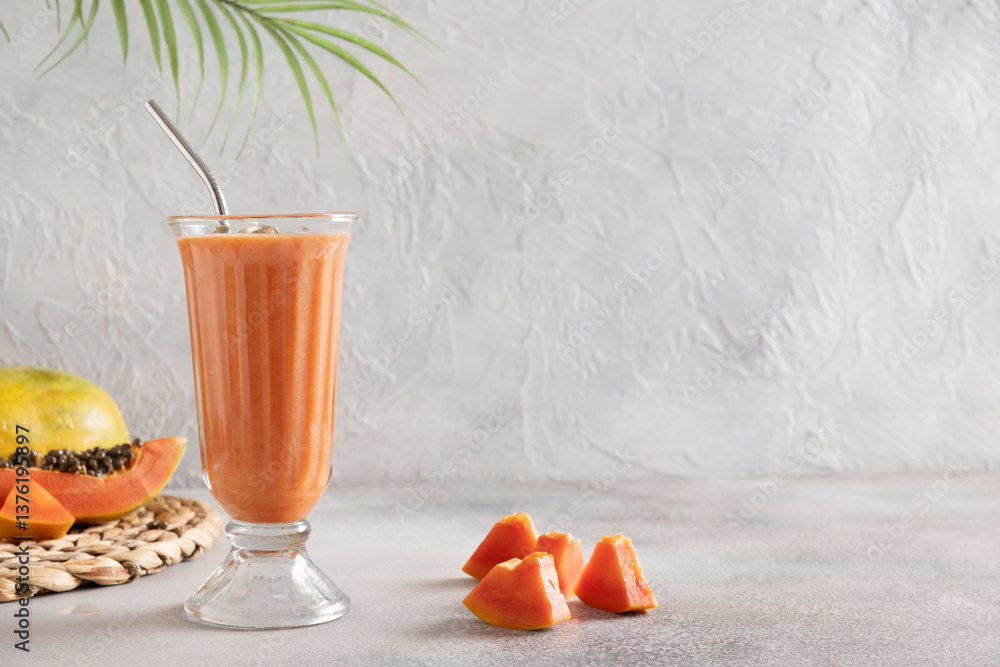 Asian traditional Papaya lassi on light gray background. Freshness cold beverage made of yogurt, water, spices, fruits and ice. Popular beverage in India and Sri Lanka. Copy space