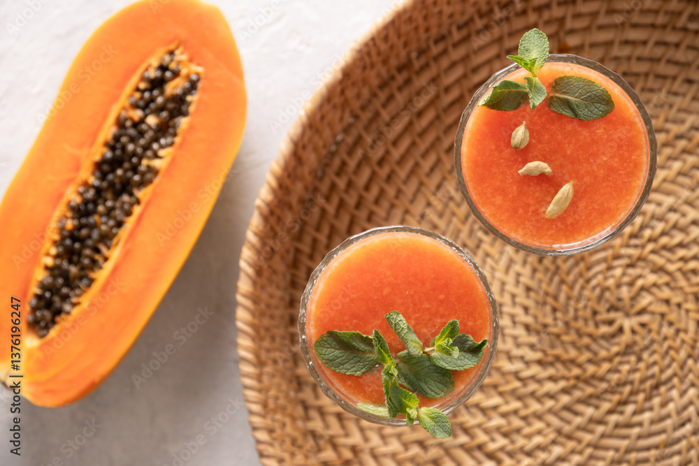 Asian popular Papaya lassi, smoothie made of water and ice. Traditional beverage in India and Sri Lanka. View from above. Close up.
