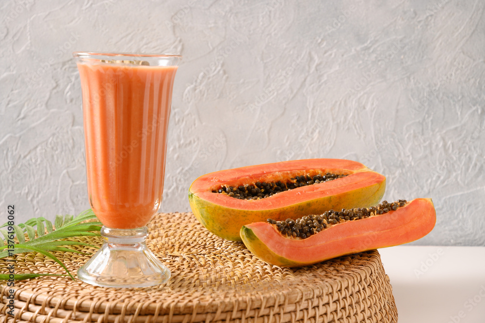Asian traditional Papaya lassi on light gray background. Freshness cold beverage made of yogurt, water, spices, fruits and ice. Summer beverage in India and Sri Lanka.