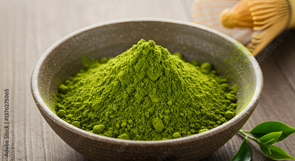 Vibrant green matcha tea powder served in a bowl alongside a bamboo whisk Vibrant green matcha tea powder served in a bowl alongside a bamboo whisk