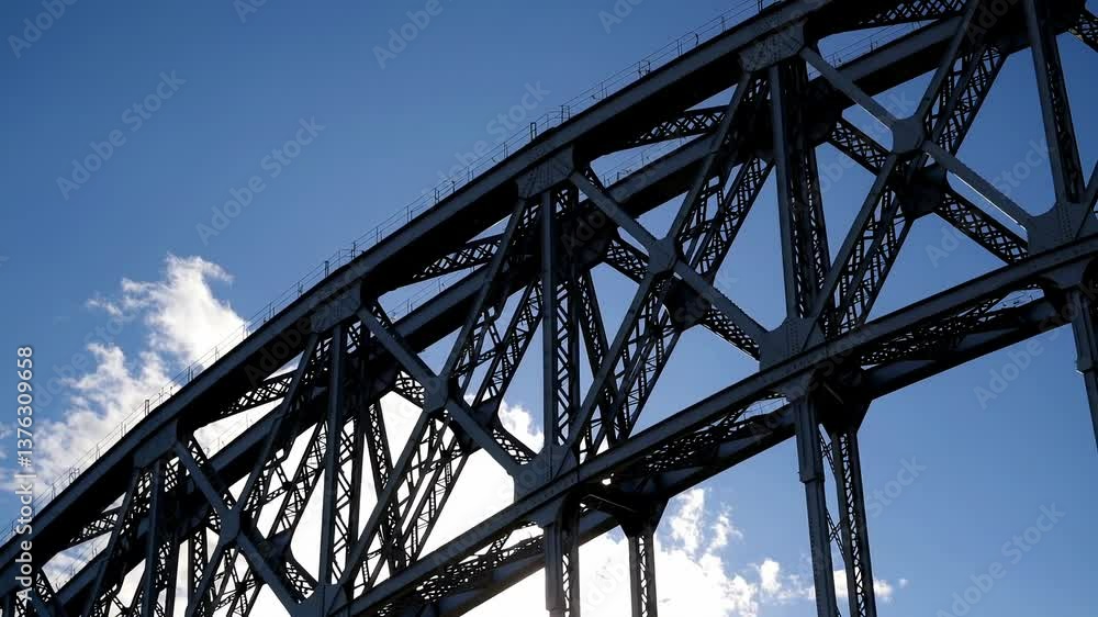Dynamic steel bridge arches against blue sky and clouds in motion Dynamic steel bridge arches against blue sky and clouds in motion