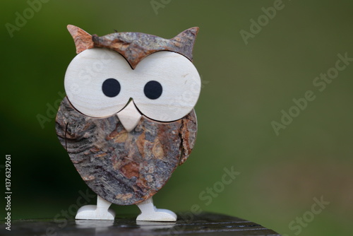 Statuetta legno piccolo gufo in primo piano con sfondo bokeh naturale