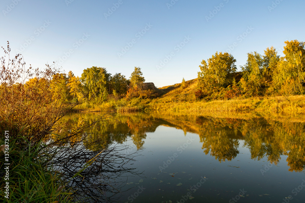 Fototapeta premium River landscape on a sunny autumn morning. The serenity and tranquility of an autumn morning on the banks of a narrow rural river.